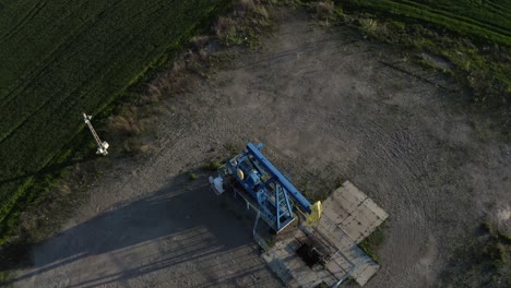 Vista-Aérea-De-Una-Bomba-De-Aceite-Que-Opera-En-El-Campo-Petrolero-Cerca-De-Ploiesti,-Rumania-Durante-El-Día