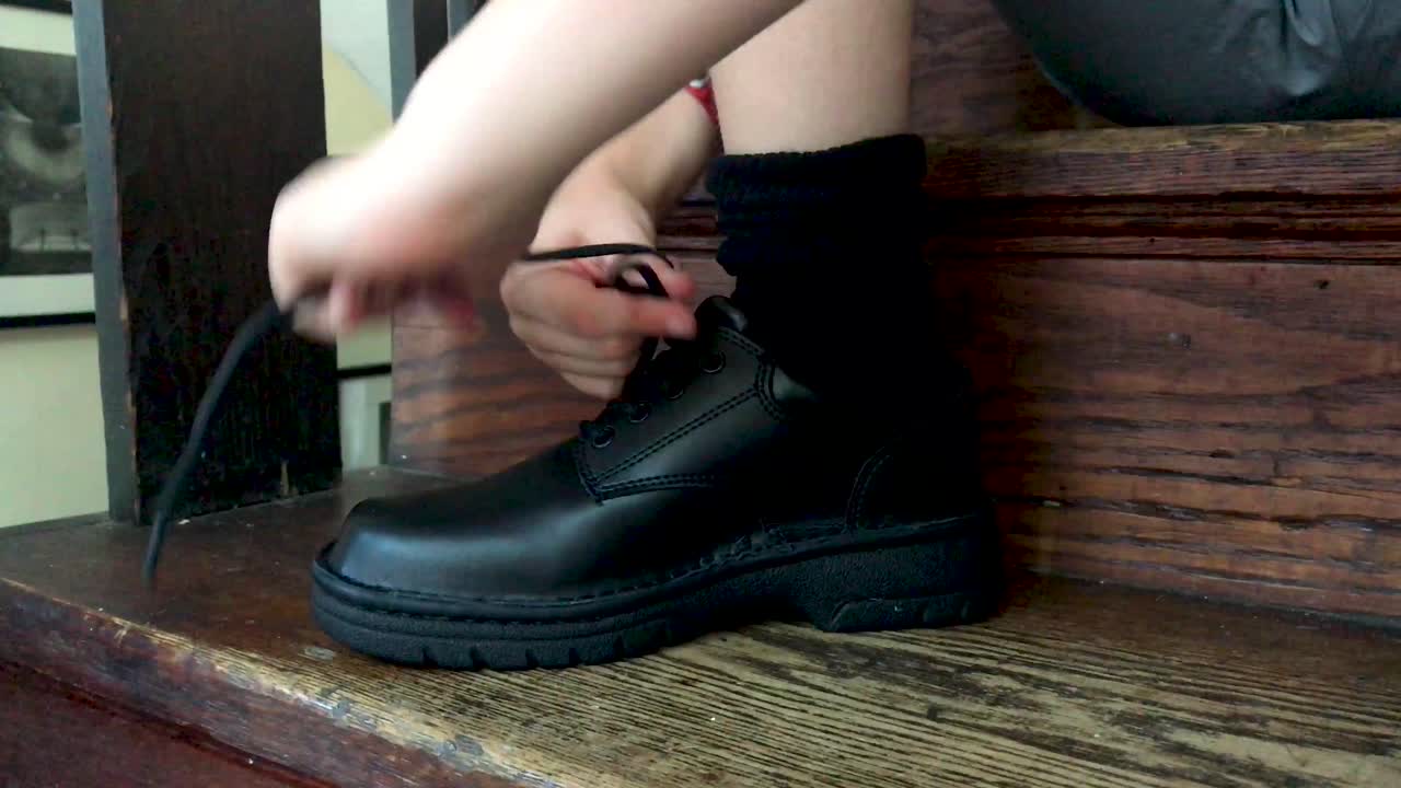 niño está atando zapatos antes de la escuela, mientras está sentado en los escalones