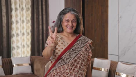 Happy-Indian-old-lady-showing-victory-symbol