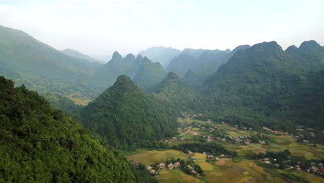 越南綠色茂盛的森林山丘的空中景色,下面是山谷中的當地村莊