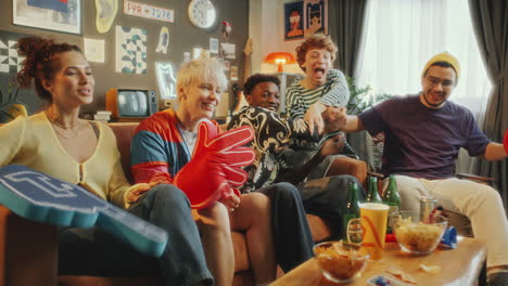 excited friends cheering while watching sports game on tv at home