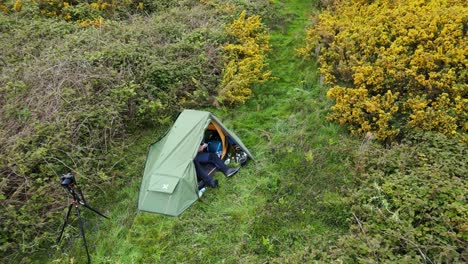 Backward-drone-shot-of-Kessingland-Beach-with-tent-on-high-ground-full-of-greenery-in-Suffolk,-England