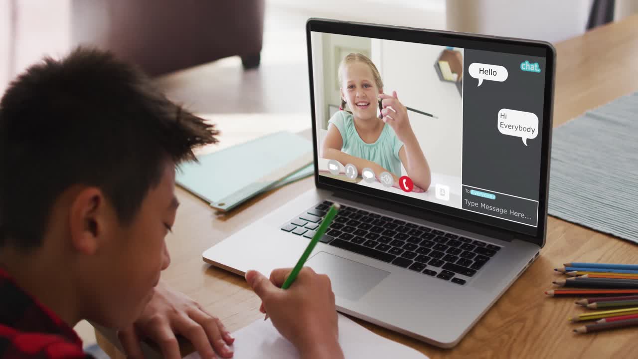 escolar que usa una computadora portátil para una lección en línea en casa, con un amigo de la escuela y un chat web en la pantalla