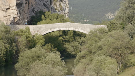 ancient stone arch bridge over a river in a mountain valley