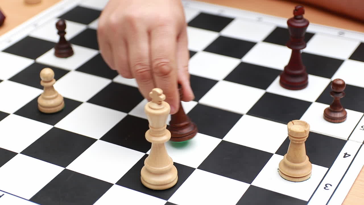 Portrait of two unrecognizable people are playing chess on a wooden background. People are playing chess concept
