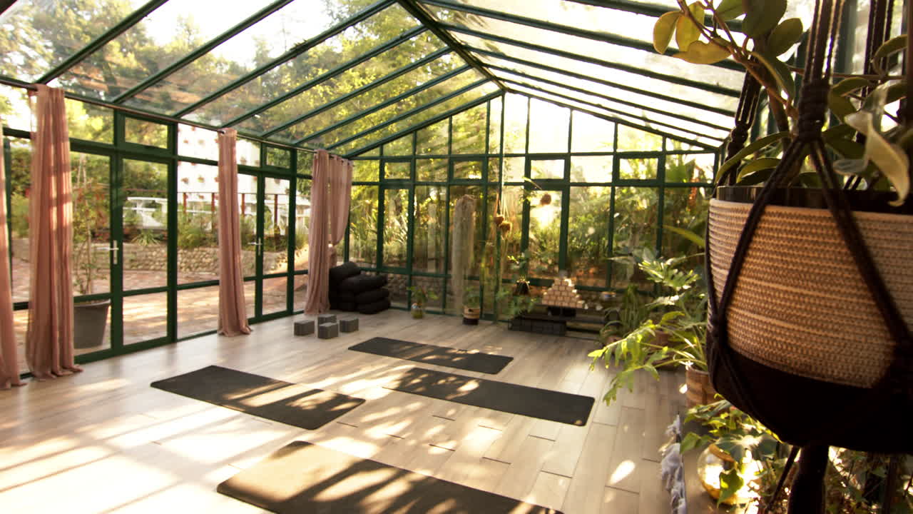Yoga mats and blocks arranged in glass house for peaceful yoga practice