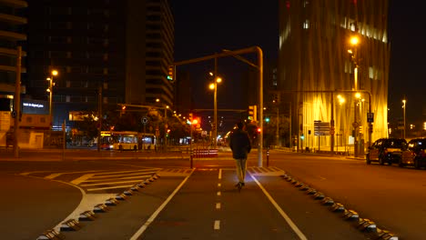 young male riding electric scooter along urban city street pavement at night