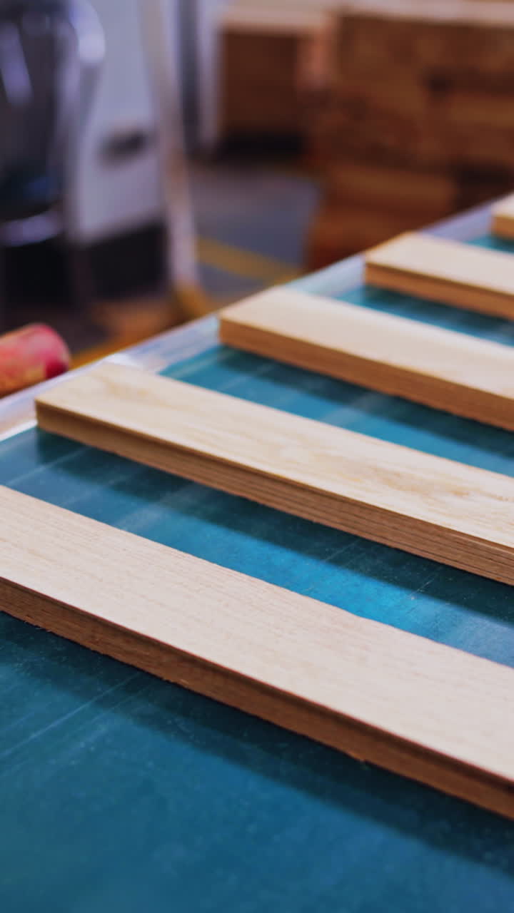 Wooden boards moves in a conveyor line. Manufacturing for parquet floor production. Modern industrial workshop for furniture production. Vertical video