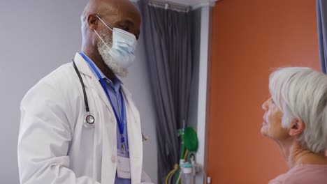 African-american-male-doctor-examining-the-neck-of-senior-caucasian-female-patient-at-hospital