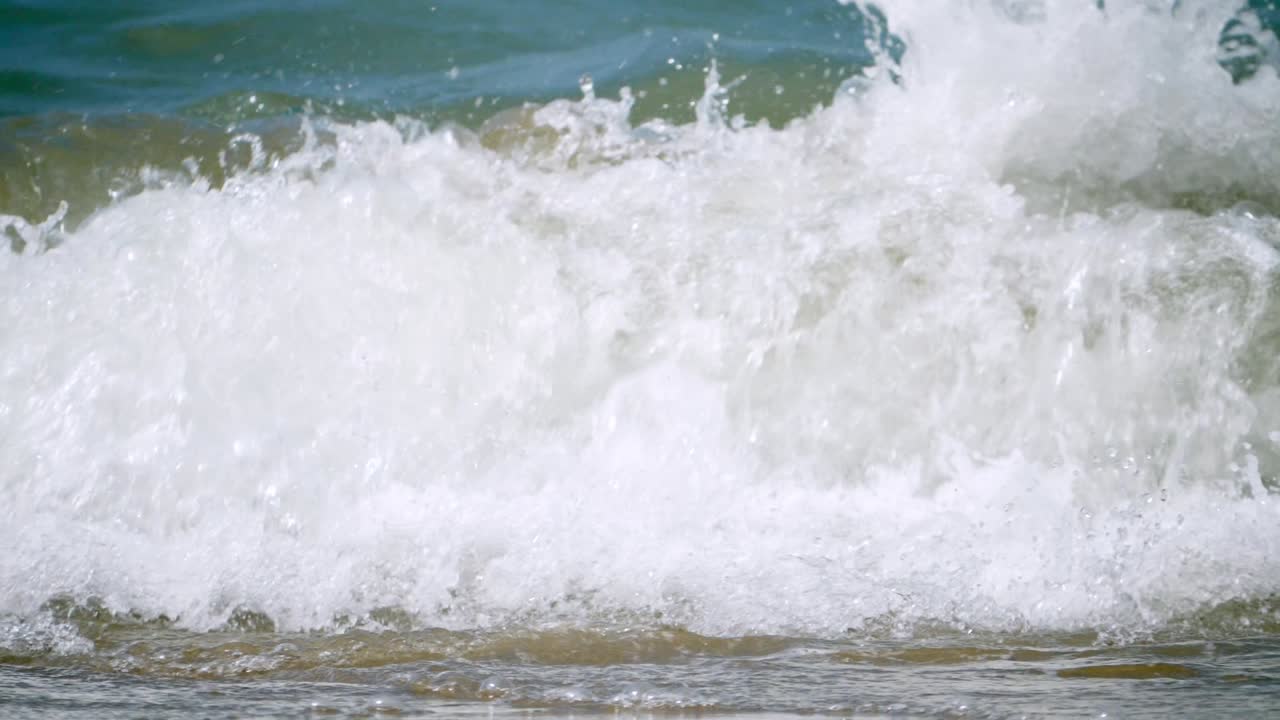 Foamy waves surging and crashing as it pounds the beachfront of Pattaya Beach, located in Chonburi province in Thailand