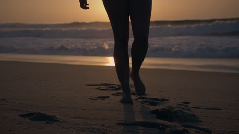 la chica se aleja del mar al atardecer.