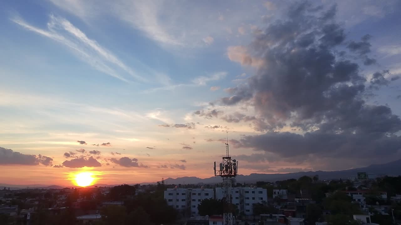 Pan drone shot of Jiutepec cityscape, fire sky and sunset in Morelos, Mexico