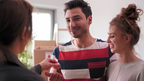 Female-realtor-handing-key-to-man