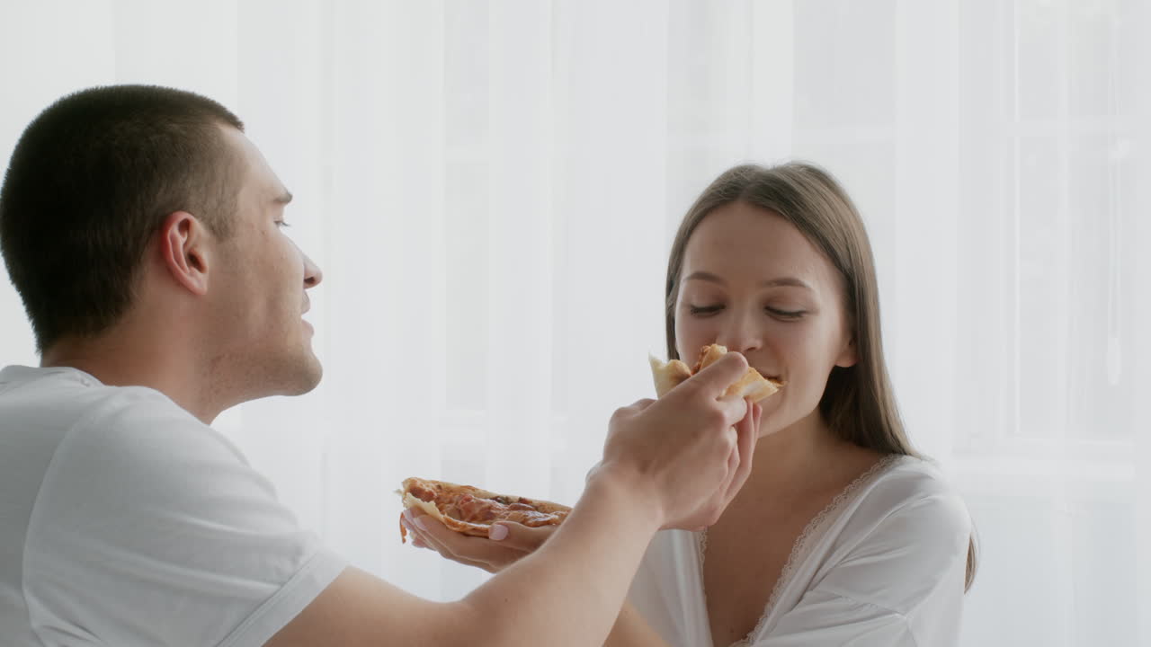una pareja compartiendo pizza.