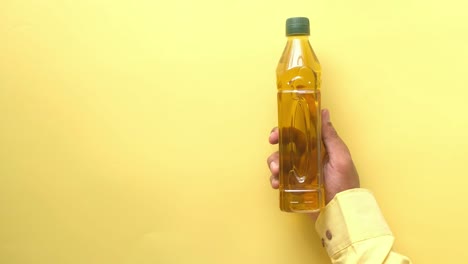 hand holding a bottle of cooking oil