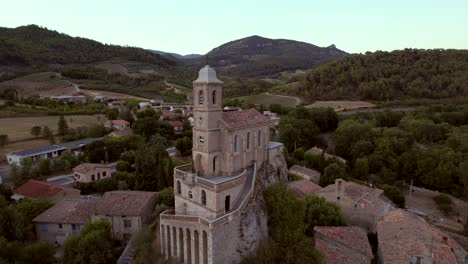 The-chapel-Notre-Dame-de-la-Consolation,-built-in-1894-atop-a-rocky-spur-overlooking-a-village-in-Pierrelongue