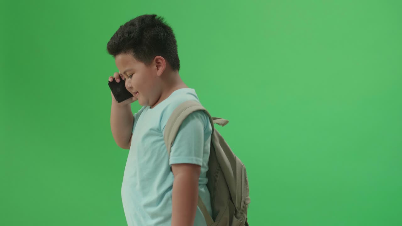 Bambino che parla al telefono con uno zaino.