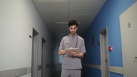 doctor using tablet in hospital hallway