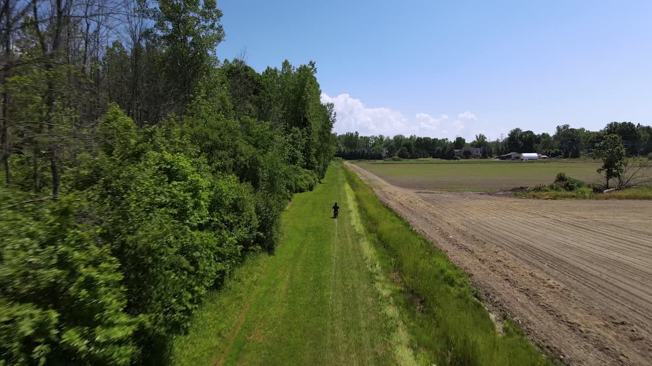 농장의  ⁇ 에 있는 초록색 공간에서 작은  ⁇  자전거를 타고 있는 남자의 공중 전망