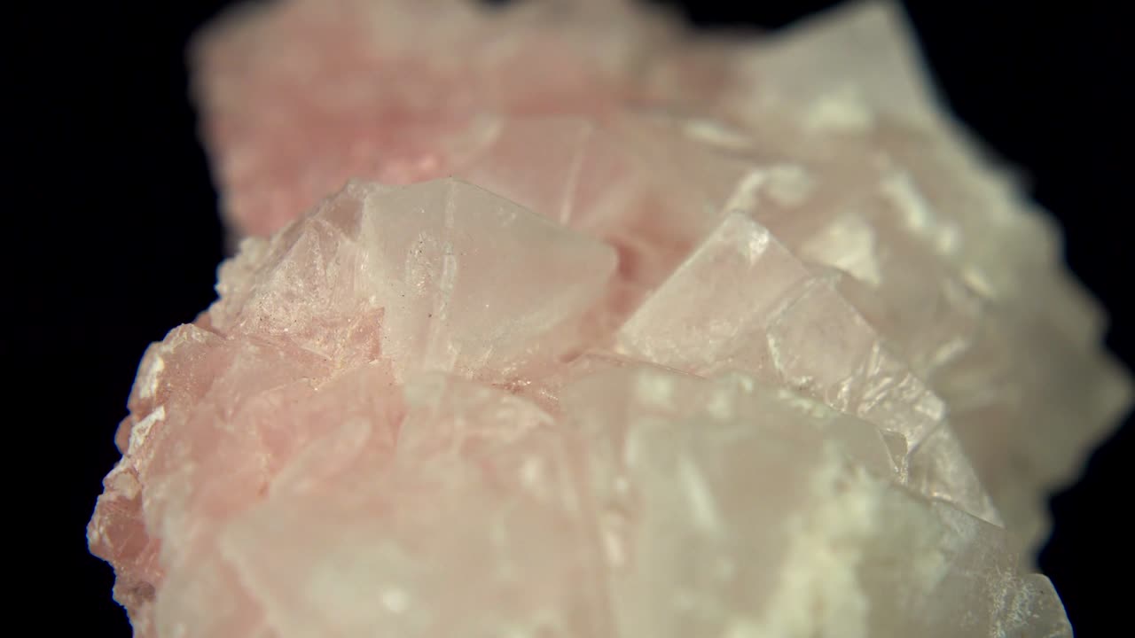 rotación sin problemas de un mineral rosado (halita rosada) frente a un fondo negro