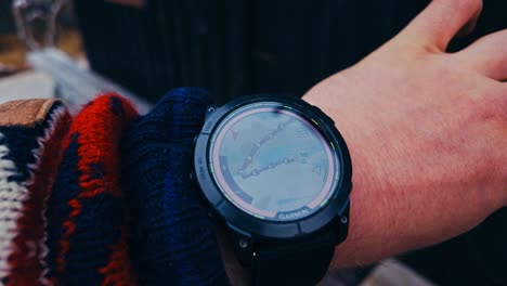 man wearing watch showing map trail - hiking watch. - closeup shot