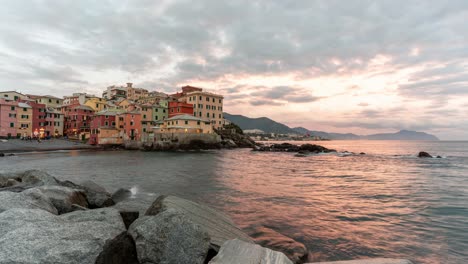 colorful boccadasse village by the sea during sunset, with waves crashing on the rocks, timelapse