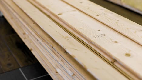 close up of a carpenter sliding a long piece of wood panel from a stack in 4k