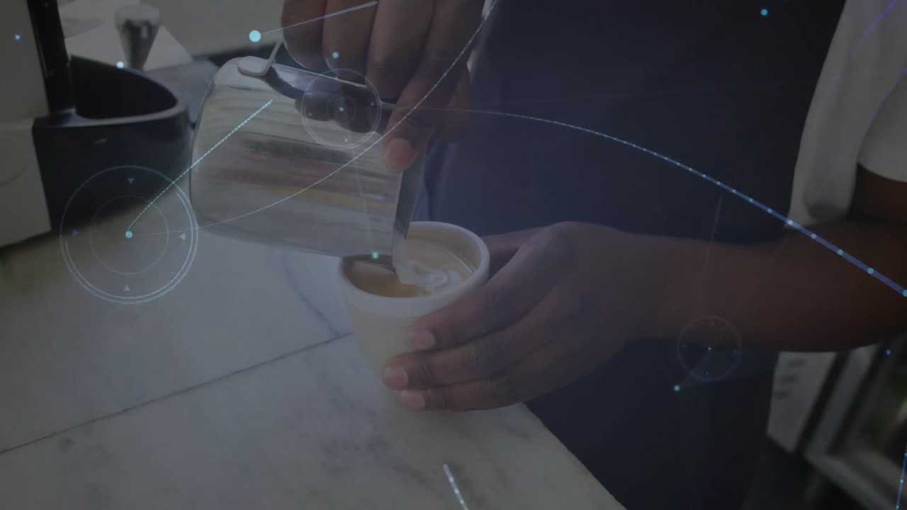 Barista pouring steamed milk into espresso cup on counter in coffee bar featuring HUD graphics