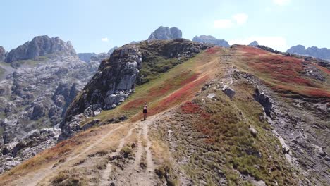 mujer camina por la cresta de una montaña en el parque nacional de prokletije, montenegro - dolly circular aéreo