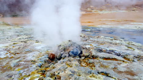 walk to icelandic geothermal steam vent fumarole tilt up to rising cloud of steam