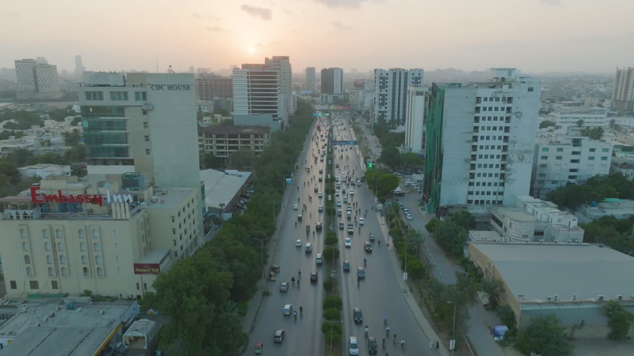 un dron se desliza a través de los cielos de la ciudad cerca del edificio del cdc en karachi, pakistán, durante una noche nublada mientras el sol se pone