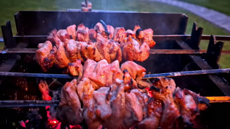 turning grilling meat skewers over hot coals on open barbecue in outdoor setting