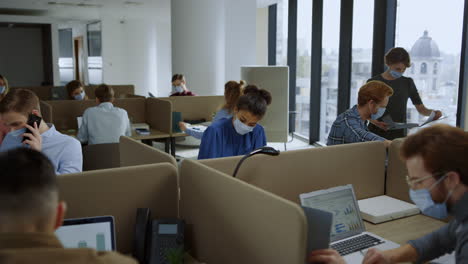 businesswomen and businessmen working in office during coronavirus pandemic