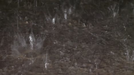 rain drops hitting a concrete sidewalk during a heavy rain storm