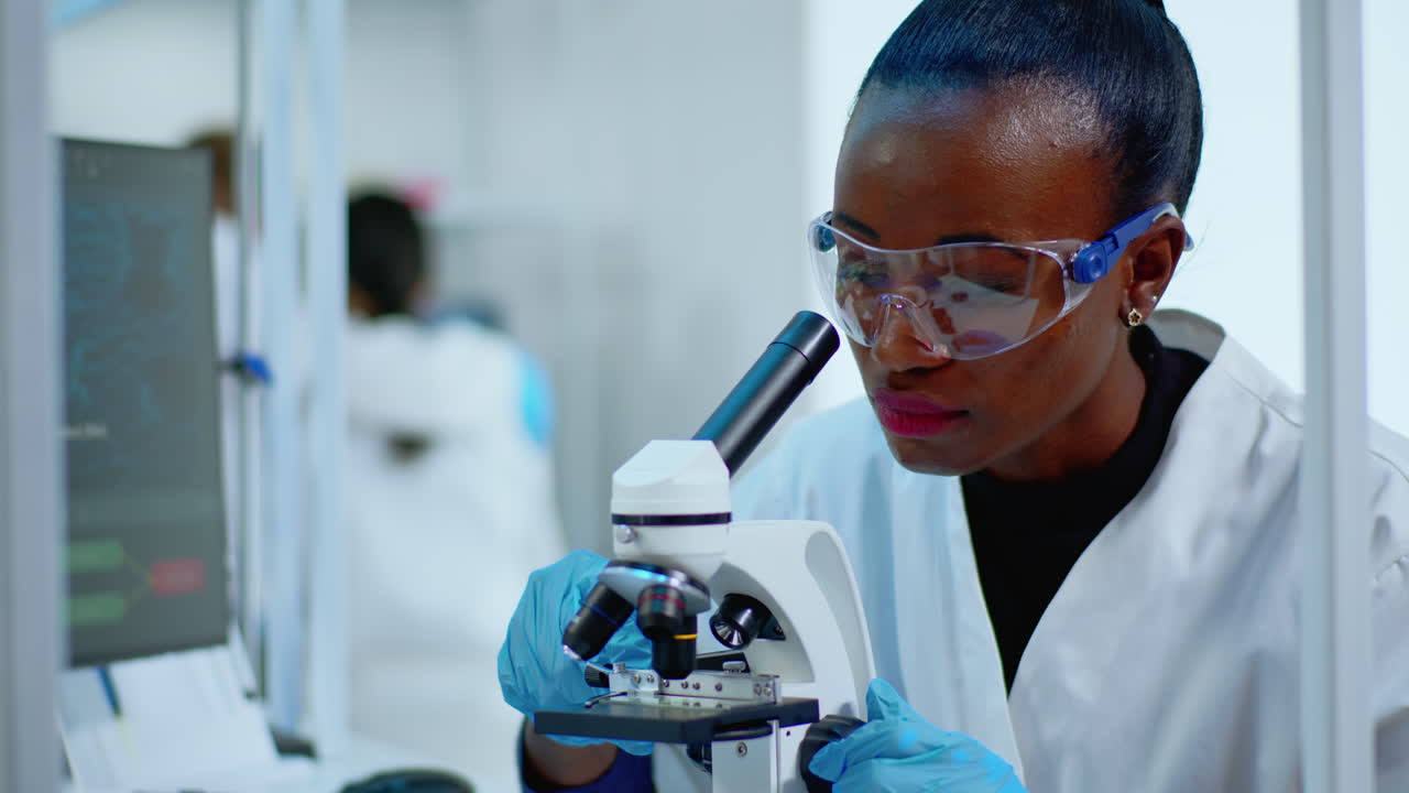 Close up of black woman looking in microscope