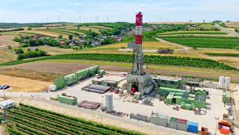 oil rig drilling on agricultural land in austria - aerial drone shot