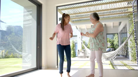 abuela asiática y nieta biracial bailando en el patio