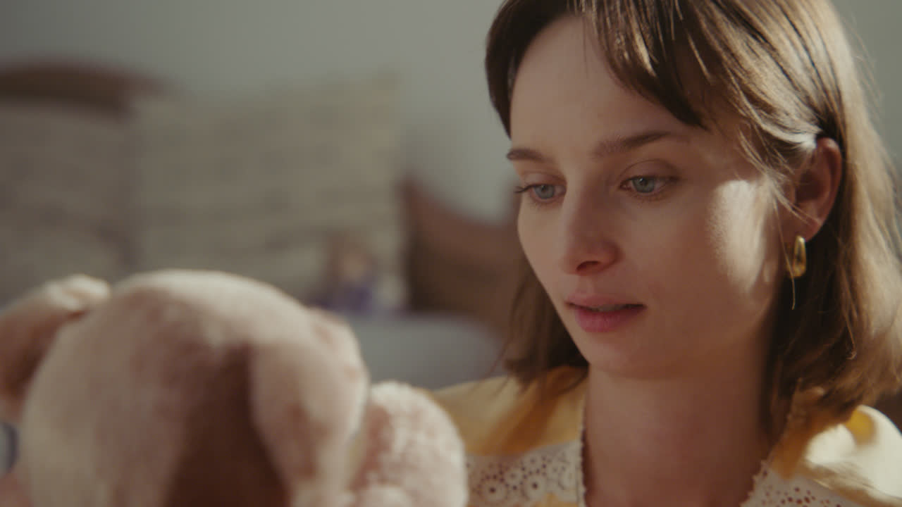 A girl playing with dolls in her room