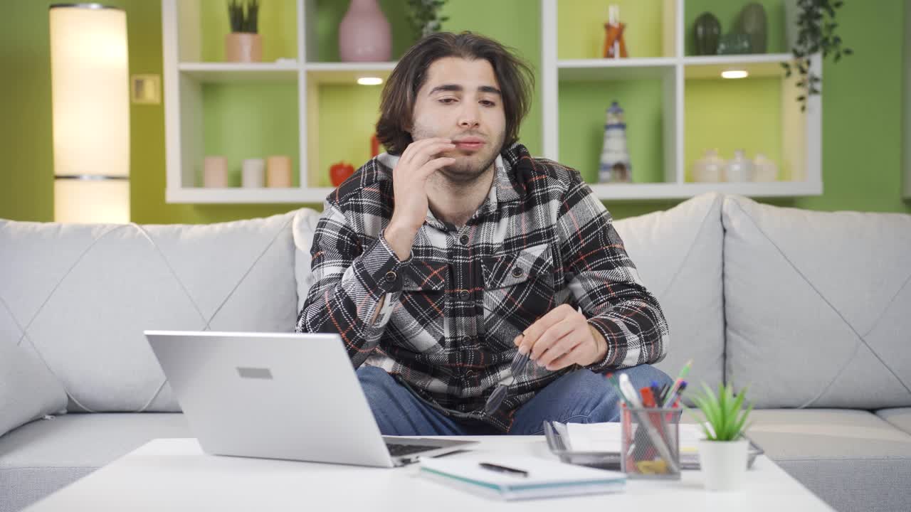 un adolescente estresado trabaja en su oficina en casa y su negocio no va bien.