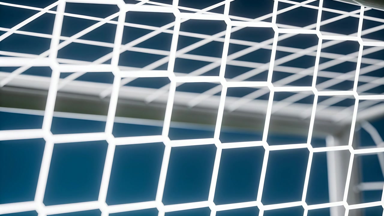 Wellenförmiges weißes Fußballtornetz flattert im sanften Wind auf einem Fußballplatz, die Querlatte ist sichtbar.
