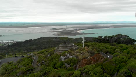 Pareja-En-El-Mirador-De-Bluff-Hill-Con-El-Océano-Y-El-Paisaje-En-El-Fondo-En-Un-Día-Nublado---Nueva-Zelanda---Drone-Aéreo