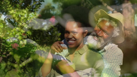 animation of plants over african american couple embracing in garden