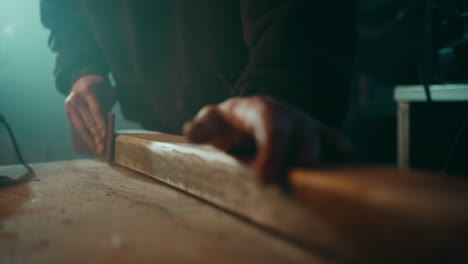 sanding down the surface of a wooden plank to get it ready for painting