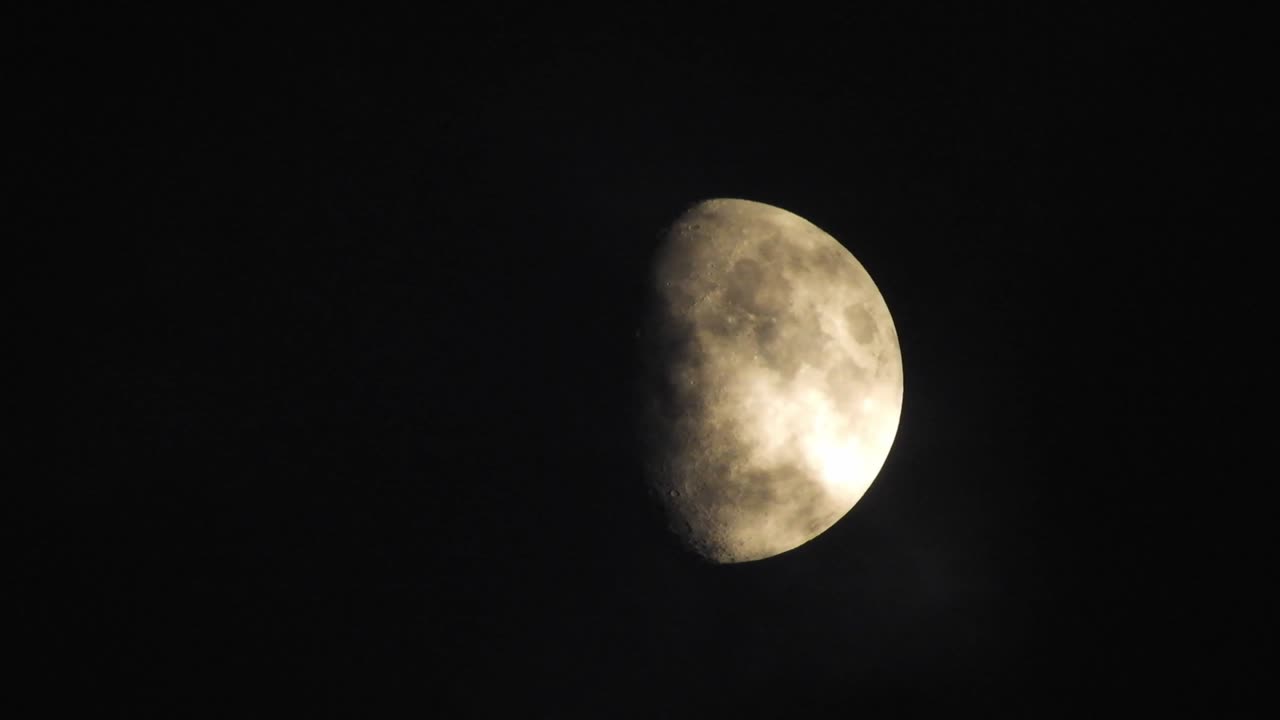 Moon at night with cloud real time. 4k video moon in the black sky.  Clouds passing by moon at night. night sky with cloudy weather
