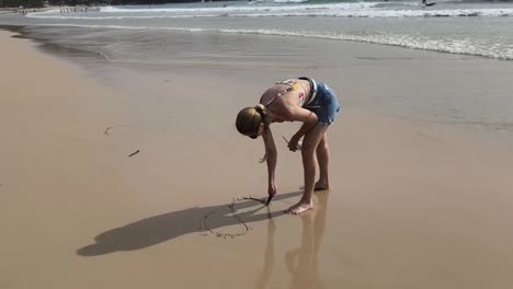 woman drawing on the beach