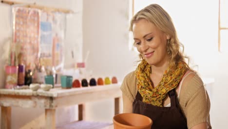 beautiful female potter painting on pot