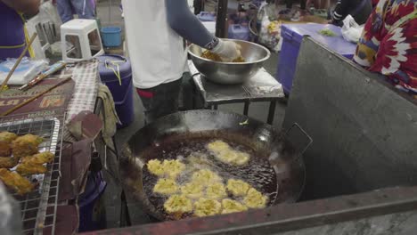 Hombre-Asiático-Friendo-Comida-En-Un-Concurrido-Mercado-En-Bangkok,-Tailandia