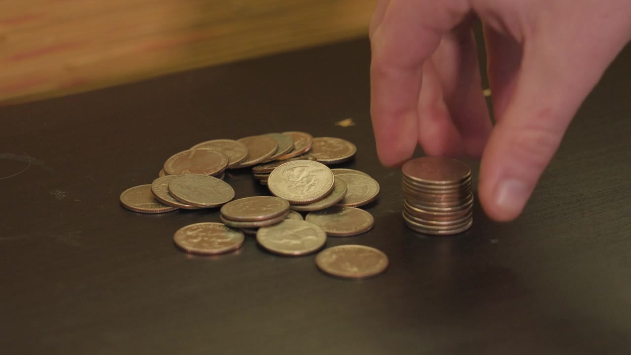 Softly placing a stack of Quarters on the table near the pile.