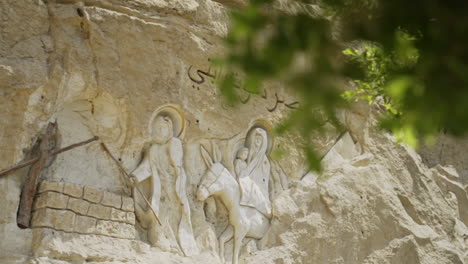 christian carvings outside cave church in cairo egypt with leaves in foreground