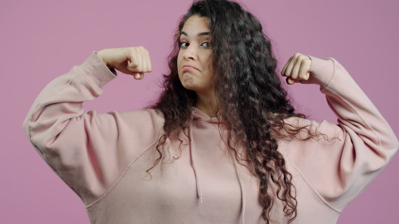 Woman Flexing in a Pink Hoodie